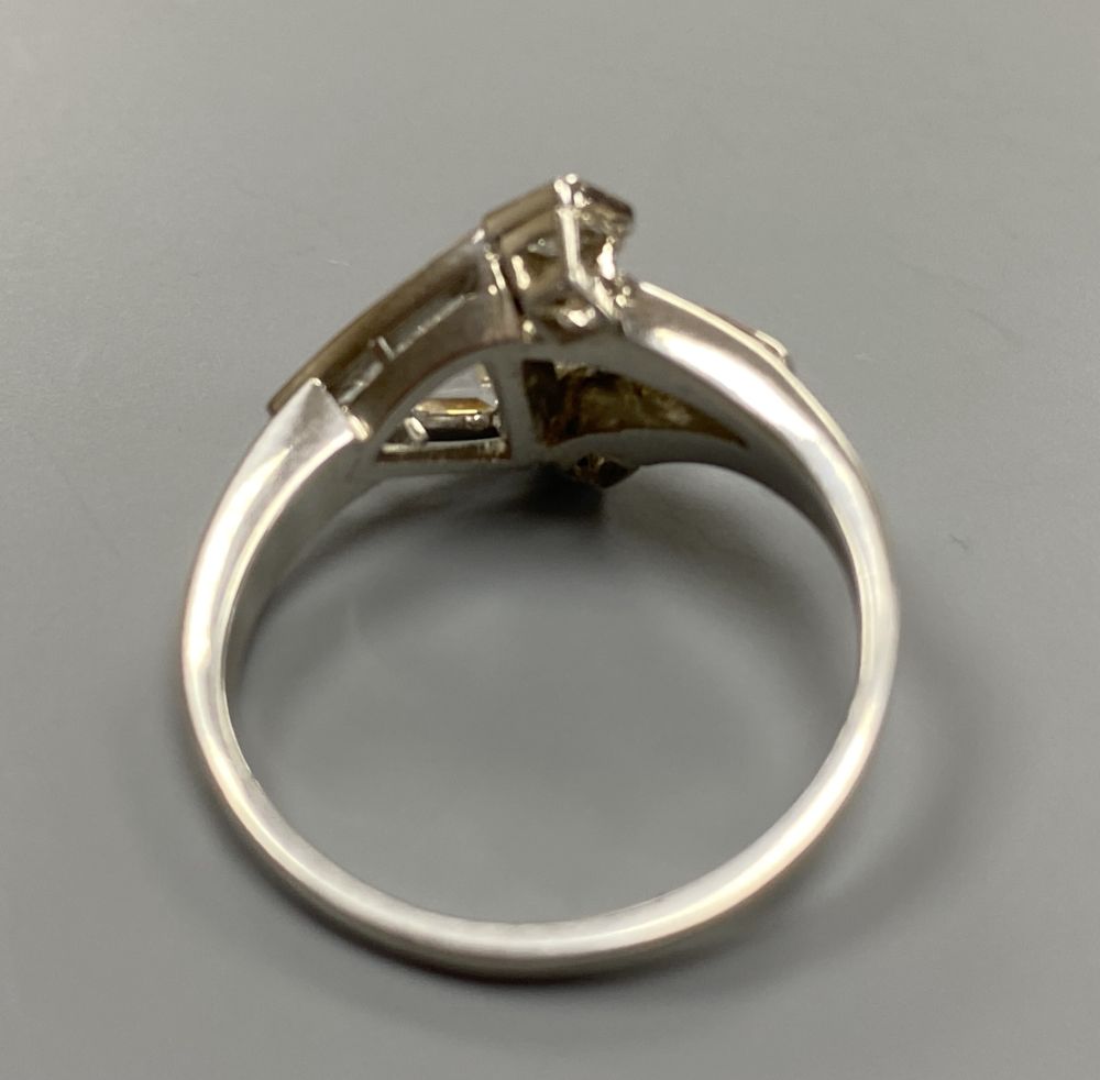 An unusual white metal (stamped Plat), triangular, square and graduated baguette cut diamond cluster set dress ring,